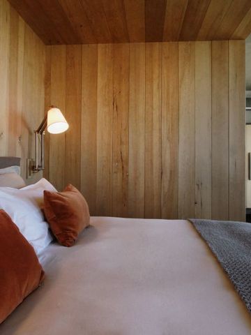 Schlafzimmerdetail mit Holzelementen und bequemen Kissen