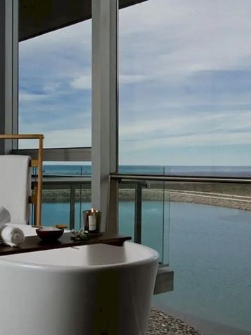 Freistehende Badewanne mit Blick auf Wasser und Landschaft