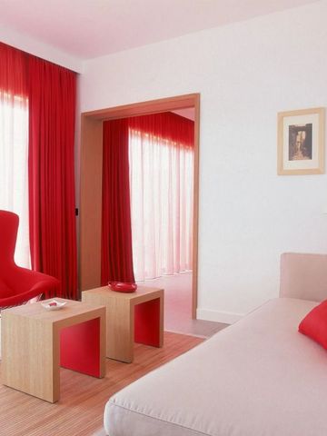 Zimmer mit roten Vorhängen und moderner Sitzgelegenheit