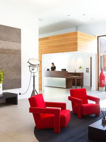Moderne Lobby mit roten Sesseln und Holzelementen