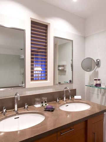 Badezimmer mit Doppelwaschbecken und beleuchtetem Spiegel