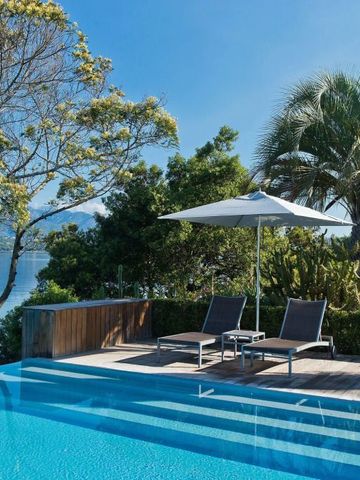 Infinity-Pool mit Blick auf das Wasser und umliegender Vegetation