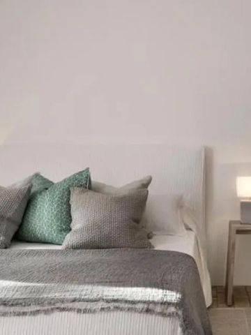 Modernes Schlafzimmer mit stilvollen Kissen und Nachttischen