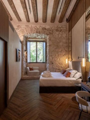 Luxuriöses Schlafzimmer mit Holz und Stein im Castilla Termal Brihuega