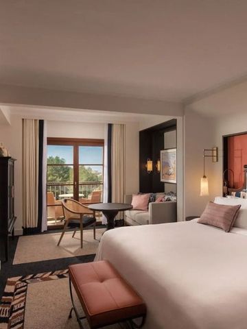 Luxuriöses Gästezimmer mit Balkon, modernen Möbeln und stilvollem Dekor.