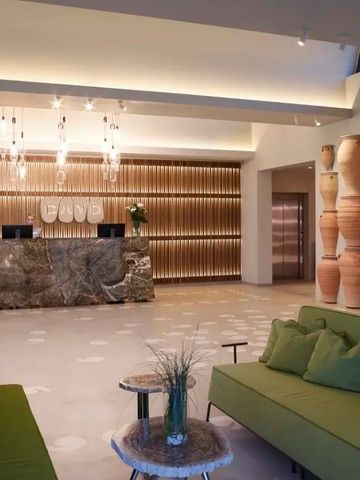 Luxuriöse Lobby mit grünen Sofas und Steinrezeption