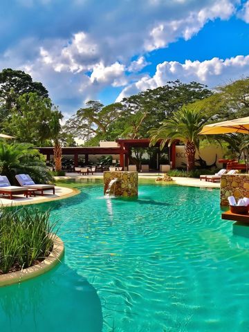 Luxuriöser Pool mit Liegestühlen und tropischer Vegetation bei Chable Yucatan