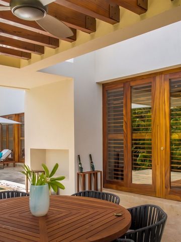 Überdachte Terrasse mit Sitzbereich und Ausblick auf den Pool in einer Villa