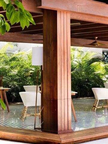 Elegante Outdoor-Terrasse mit Holzelementen und weißer Bestuhlung umgeben von Pflanzen
