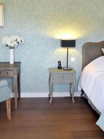 Elegantes Schlafzimmer mit pastellgrüner Wandgestaltung und Vintage-Möbeln.