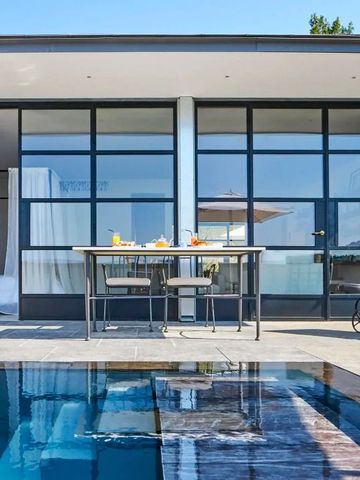 Terrasse mit Pool und Essbereich vor modernen Glasfassaden