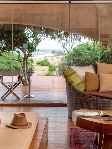 Luxuriöse Suite mit Terrasse und Blick auf tropische Vegetation und Meer