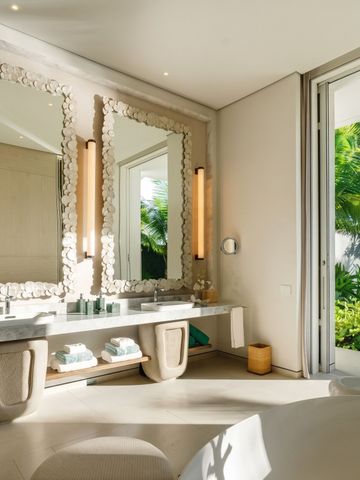 Elegantes Badezimmer mit zwei großen Spiegeln und Gartenblick.