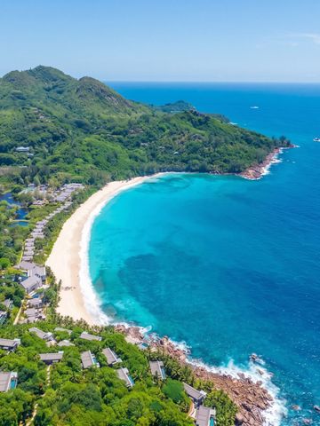 Luftaufnahme eines einsamen Strandes und üppiger Landschaft im Cheval Blanc Seychelles