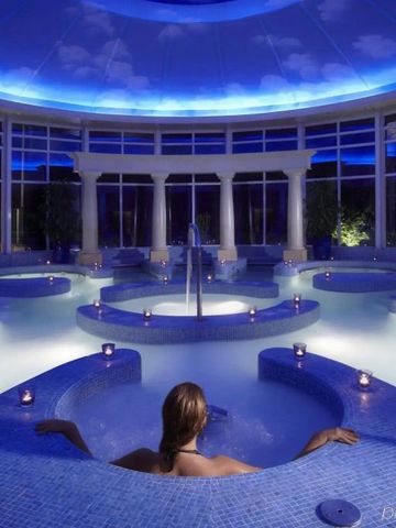 Luxuriöser Spa-Bereich mit blauen Mosaik-Fliesen und entspannender Beleuchtung.