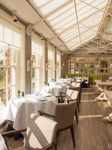 Elegantes Restaurant mit gedeckten Tischen und großen Fenstern im Chewton Glen Hotel
