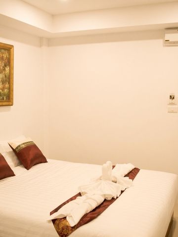 Schlafzimmer mit dekorativen Kissen und Wandkunst in warmer Beleuchtung
