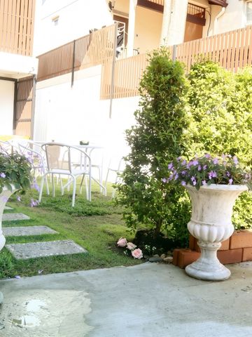 Hinterhof mit Pflanzen, Gartenmöbeln und Holzverkleidung