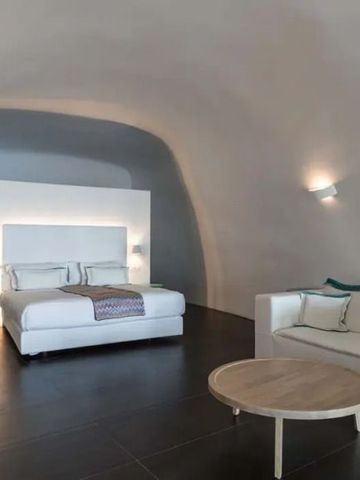 Geräumiges Zimmer mit Höhlenarchitektur und stilvoller Einrichtung im Katikies Chromata Santorini