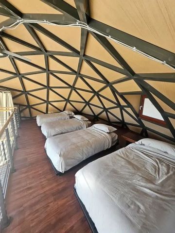 Dachgeschoss eines Geodoms mit vier Betten und Holzboden
