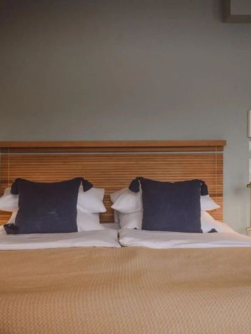 Gemütliches Doppelbett mit blauem Dekor in elegantem Zimmer