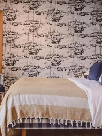 Schlafzimmer mit dekorativer Tapete und eleganter Einrichtung