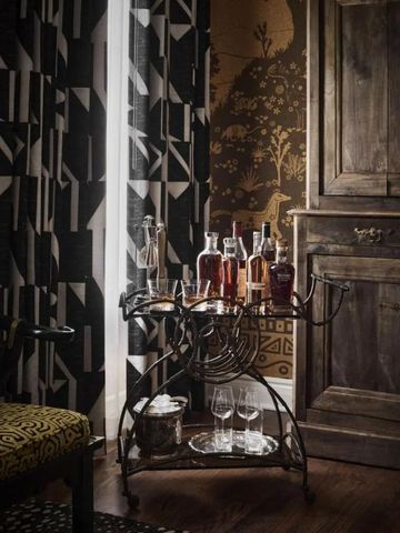 Elegante Hausbar mit Flaschen und Gläsern auf einem antiken Servierwagen