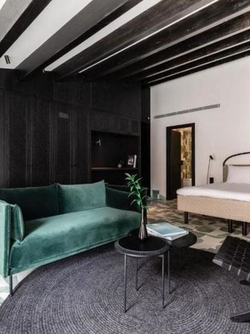Geräumiges Zimmer mit grüner Samtcouch und gemütlicher Atmosphäre