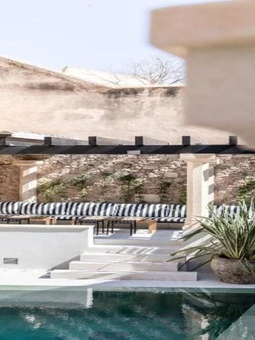 Außenbereich mit Pool, Sonnenliegen und Steinwänden im mediterranen Stil