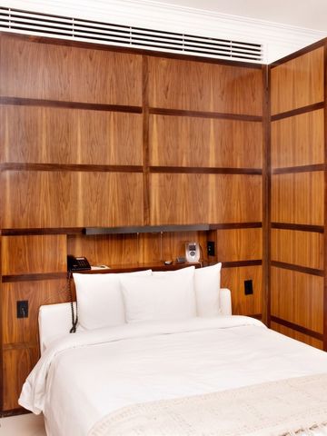 Elegantes Zimmer mit Holzwand und komfortablem Bett