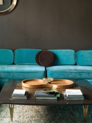 Moderne Lounge mit türkisfarbenen Sofas und elegantem Tisch