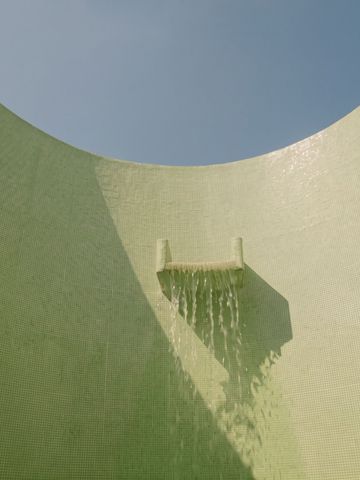 Künstlerischer Wasserfall in runder Betonwand mit Tageslichtöffnung