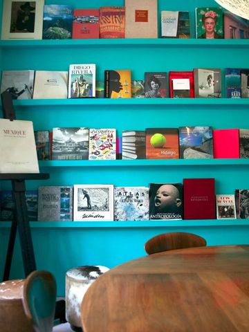 Moderne Bibliothek mit vielfarbigen Büchern auf türkisfarbenem Hintergrund