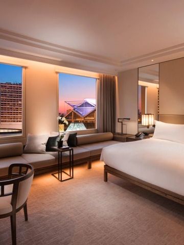Luxuriöses Zimmer mit großem Bett und Blick auf die Stadt im Conrad Singapore Marina Bay