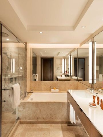 Modernes Badezimmer mit großer Glasdusche und Marmor-Verkleidung