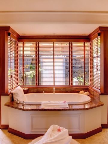 Luxuriöses Badezimmer mit freistehender Badewanne und großen Fenstern