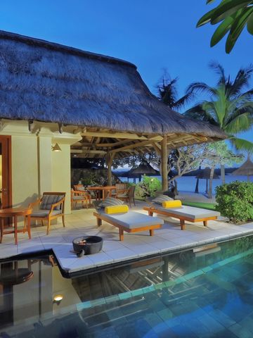 Luxusvilla mit Strohdach und privatem Pool bei Sonnenuntergang