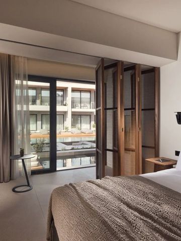 Modernes Hotelzimmer mit großem Fenster und Blick auf den Innenhof