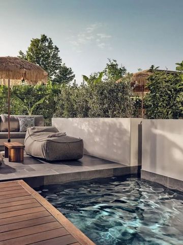 Private Terrasse mit Pool und gemütlichen Sitzmöglichkeiten unter Sonnenschirmen