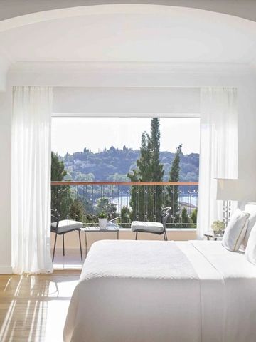 Helles Schlafzimmer mit Panoramafenster und Blick auf die Landschaft