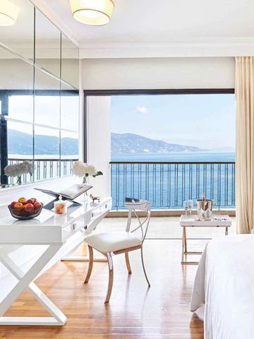 Luxuriöses Zimmer mit Schreibtisch und Panoramablick auf das Meer.