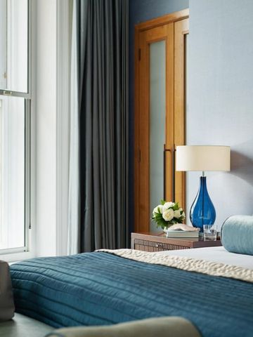 Gemütliches Schlafzimmer mit Blick aus dem Fenster und blauen Akzenten