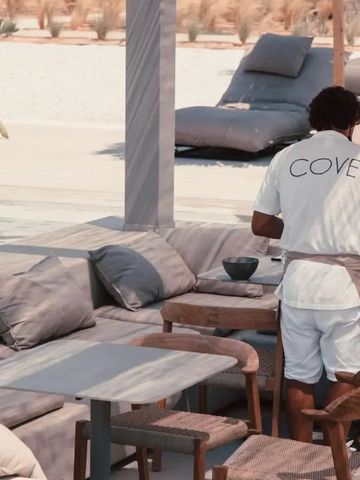 Leute entspannen in einer stilvollen Außenlounge im Cove Paros Hotel