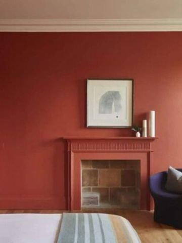 Zimmer mit roter Wand und Kamin in eleganter Atmosphäre