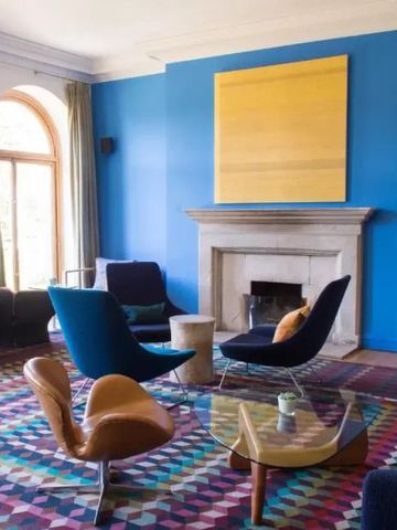 Gemütlicher Raum mit blauer Wand und stylischen Sesseln