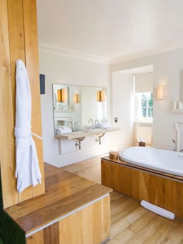 Luxuriöses Badezimmer mit Holzdetails und großem Whirlpool
