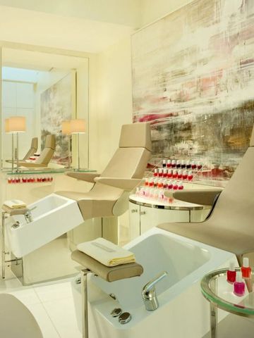 Heller Spa-Raum mit Nagelpflegeeinrichtungen und modernen Kunstwerken