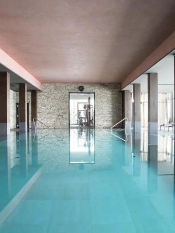 Hallenbad mit ruhigem, kristallklarem Wasser und moderner Architektur