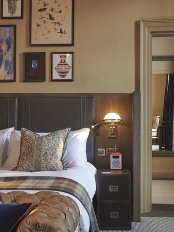 Luxuriöses Schlafzimmer mit Kunst an der Wand und eleganter Beleuchtung