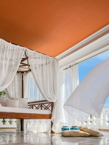 Luftiger Raum mit Himmelbett und weitem Blick aufs Meer